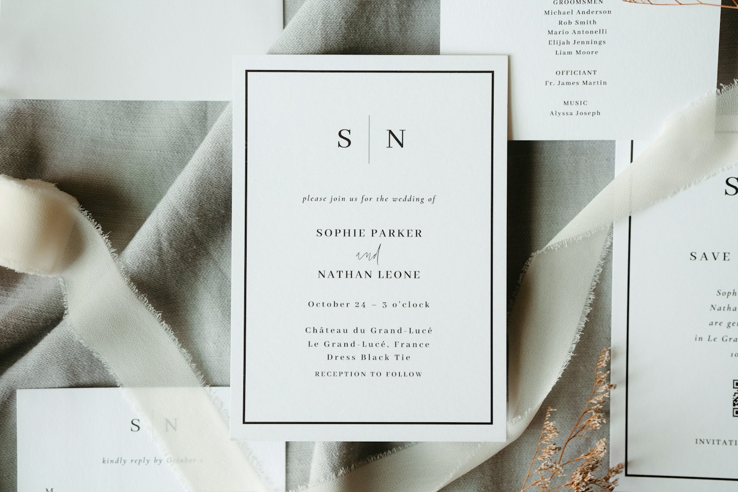 Elegantes invitaciones de boda con cinta de seda y flores secas.